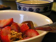 Granola cereal with almond milk, strawberries, and green tea