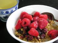 Granola cereal with cranberries, raspberries, almond milk, and green tea