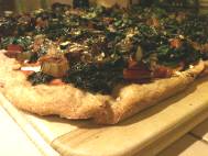 Pizza: red sauce, vegan cheese, chard, kale, green bell pepper, and onion on spelt and whole wheat crust