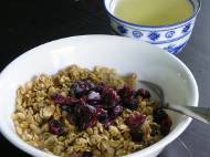 Granola cereal with almond milk, cranberries, and green tea